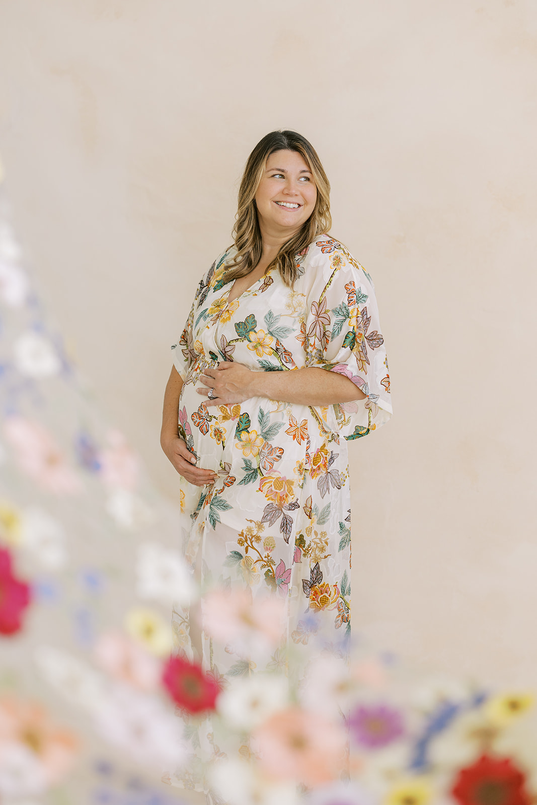 Nicole maternity portrait with flowers in foreground