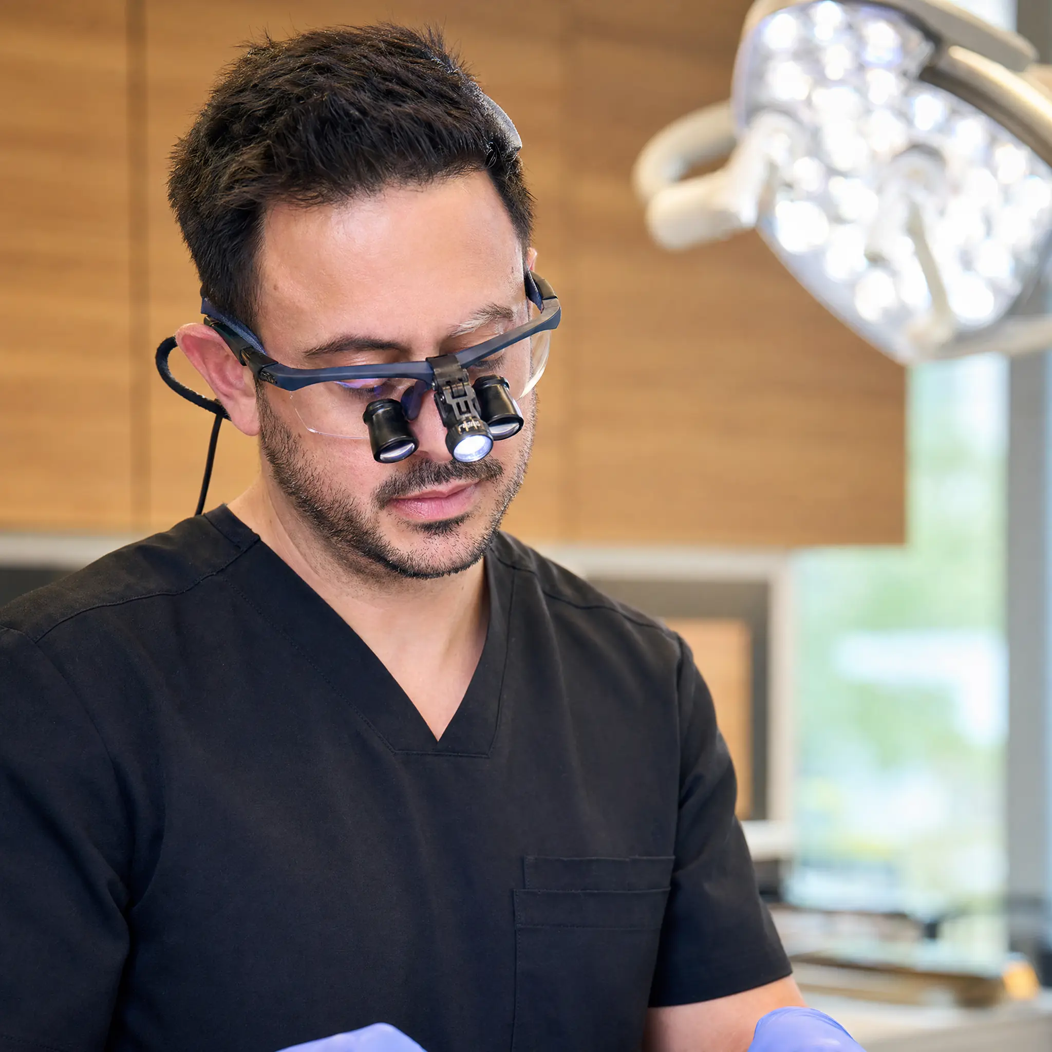 Dr. Daniel Ormeni in surgical loupes performing a wisdom tooth extraction at Park Family Dental in Cedar Park, TX