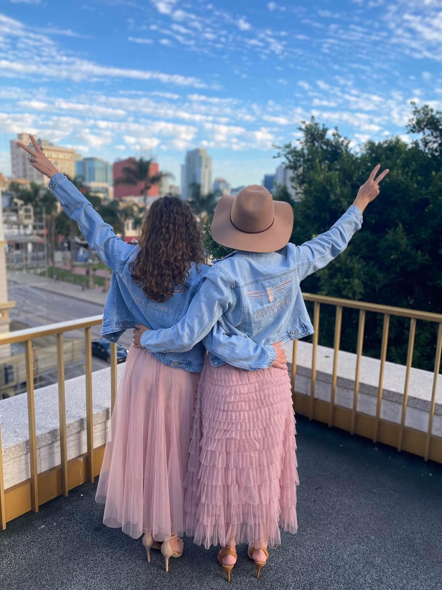 image of two woman looking over a city with peace signs