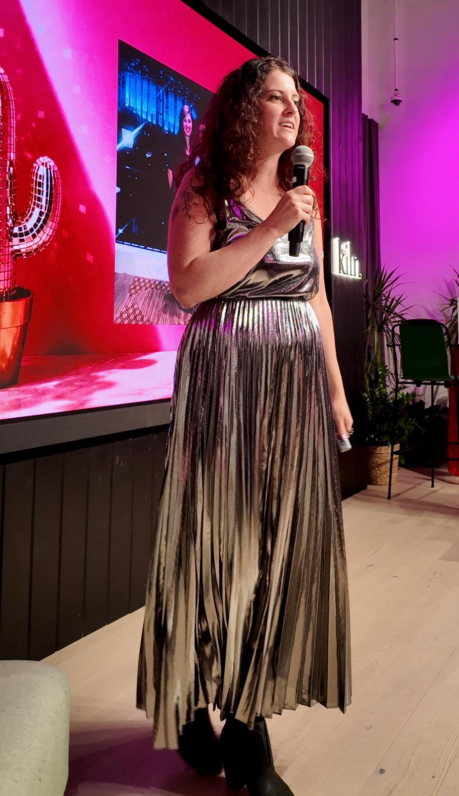 Keely Stawicki speaking into a microphone on stage.