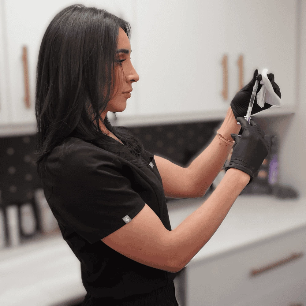 Marisa standing confidently with a syringe, representing the Botox for Beginners training session.
