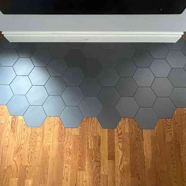 Grey hex tile hearth meeting oak hardwood at a Farwes fireplace