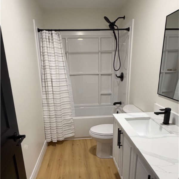 Farwes bathroom renovation with a white vanity, marble top, and black fixtures