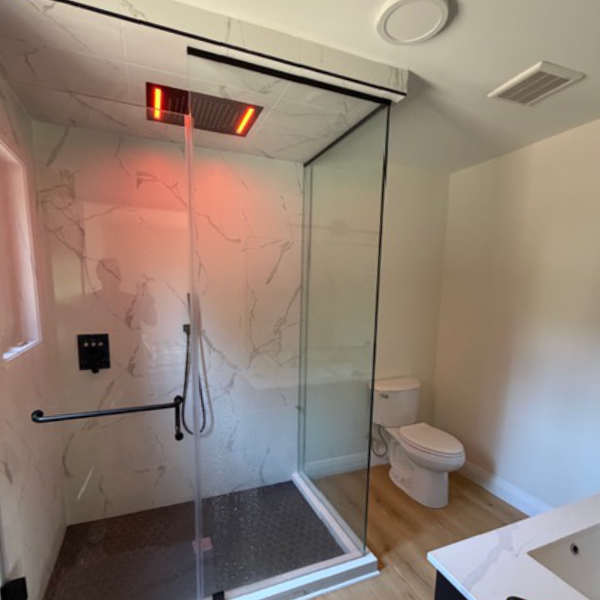 Farwes marble shower with a glass door, rain head, and black hardware