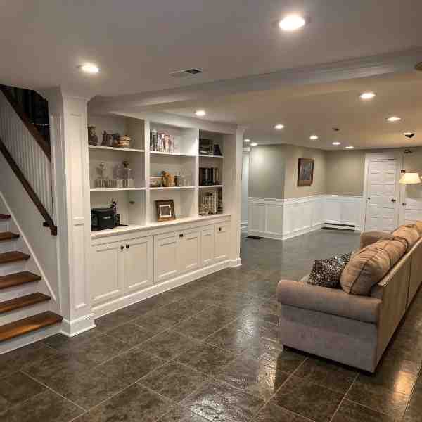 Finished Farwes basement with white millwork built-ins and a staircase