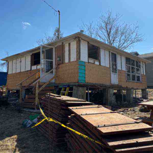 Farwes addition underway: house lifted on steel with sheathing and site materials