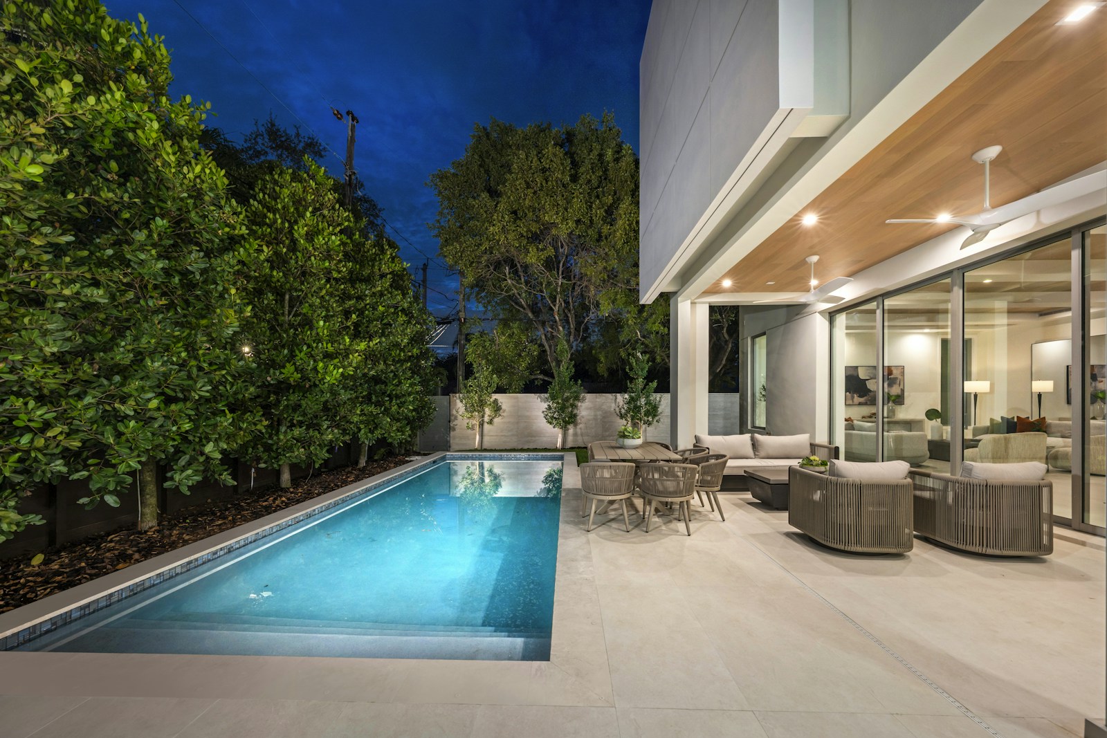 Modern pool with lighting and outdoor seating at night