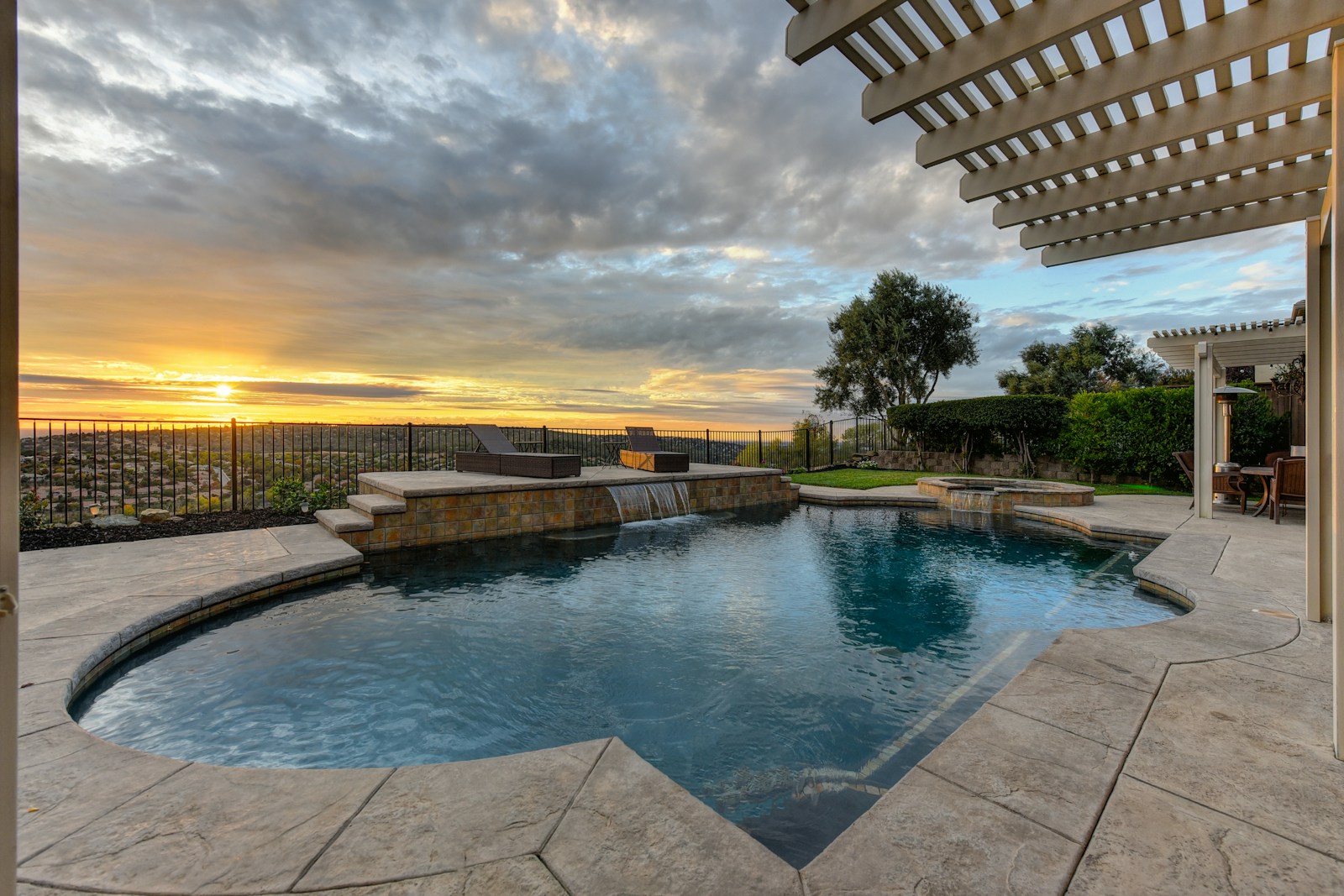 Backyard pool with stone deck and pergola at sunset, the kind of space Clearview designs in El Paso