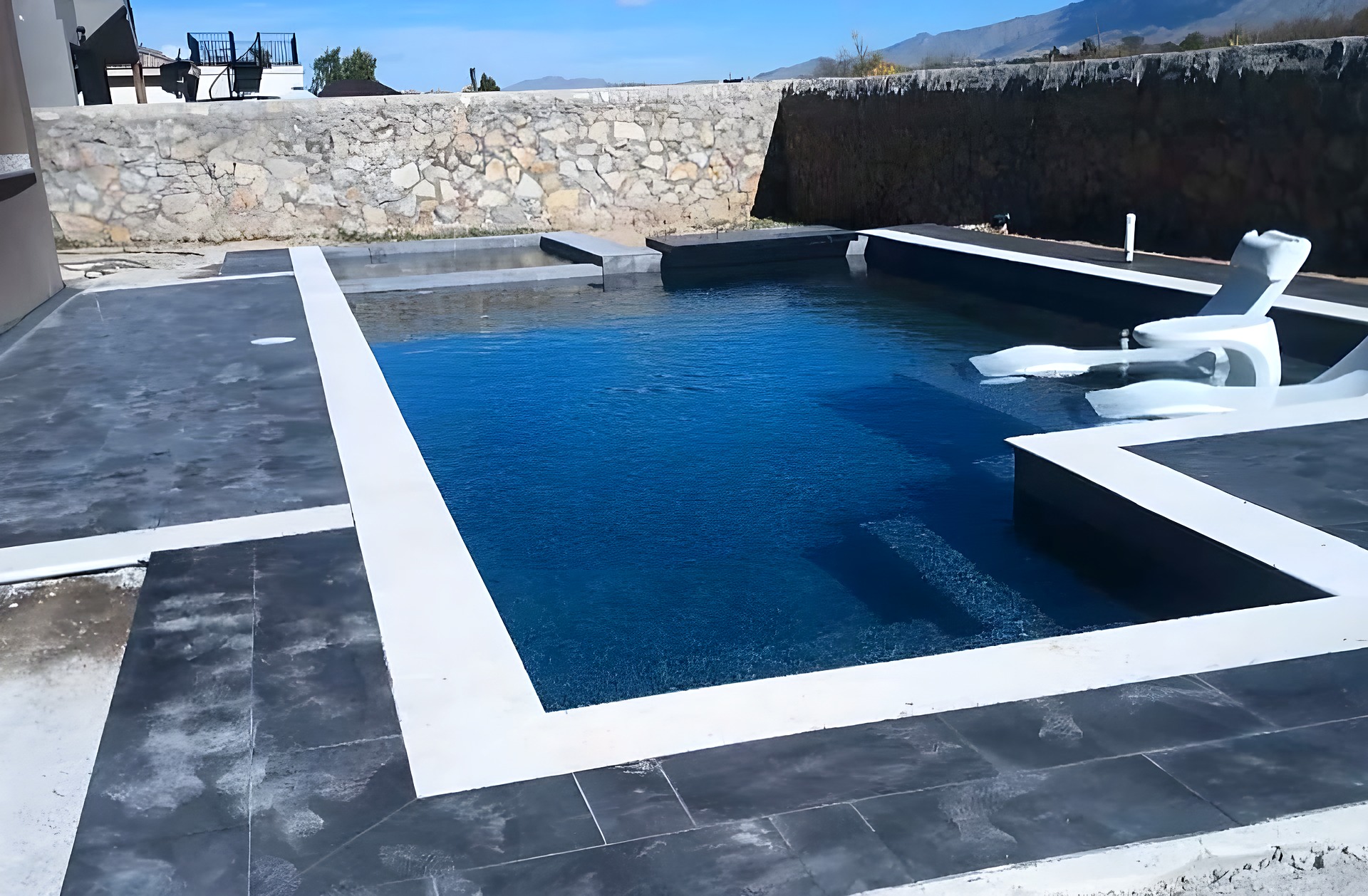 Dark-tile pool with paver deck in El Paso