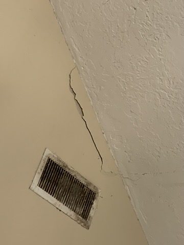 Inside: a crack and stain on the ceiling, the early sign of a leak.
