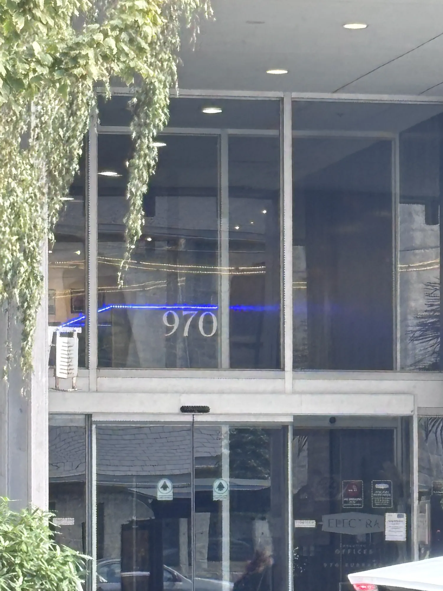 Glass entrance of 970 Burrard Street with the building number above the doors