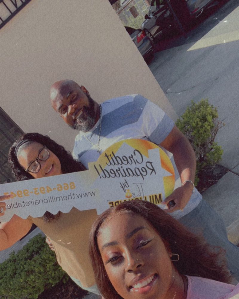 Happy clients holding Credit Repaired sign