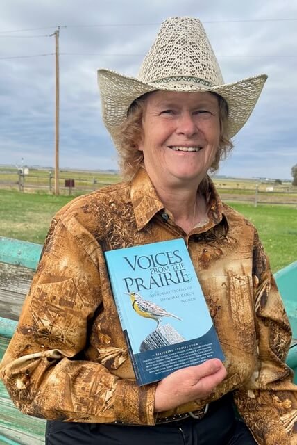 Dorothy Louise Beasley in a cowboy hat holding Voices From the Prairies at her home in Alberta.