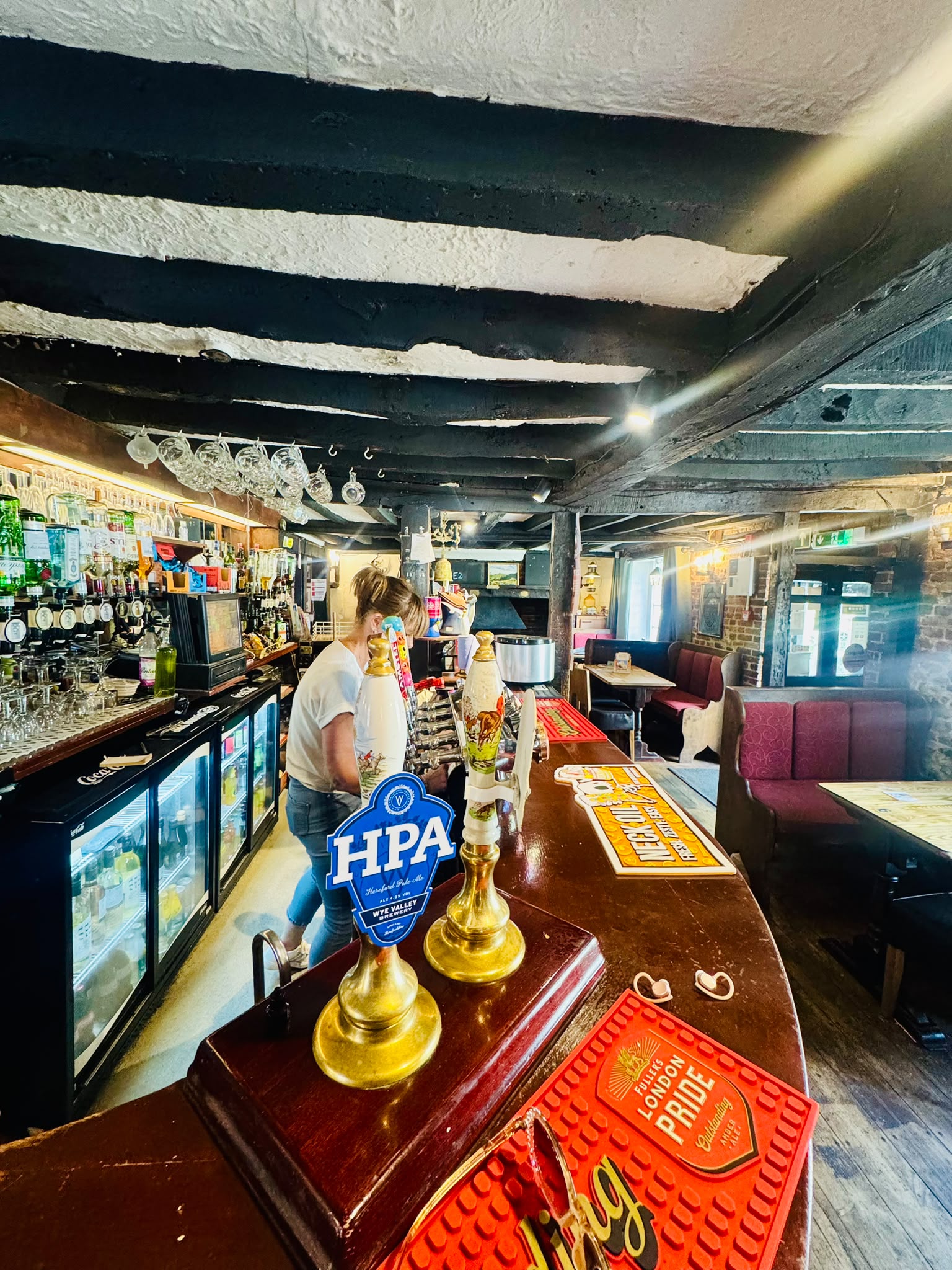 The characterful interior of The Anchor Bookham pub, with exposed beams and an open fire