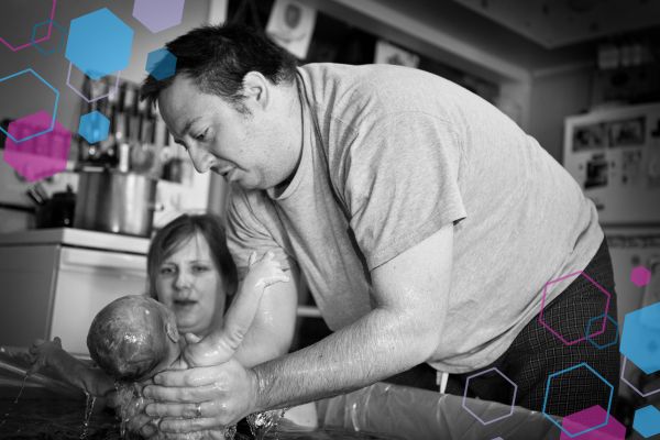 Baby being born in water with hands-on support from a birth partner during a home water birth, illustrating the physical process of birth and how environment and support interact with labour physiology. Baby being born in water with hands-on support from a birth partner during a home water birth, illustrating the physical process of birth and how environment and support interact with labour physiology.