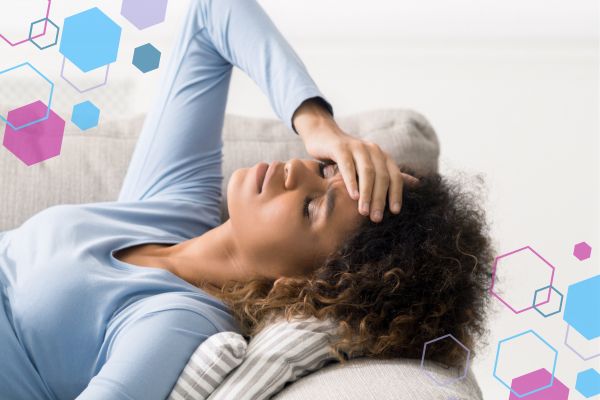 Person resting with a hand on their forehead, representing dizziness or lightheaded feelings in early pregnancy around 5–9 weeks