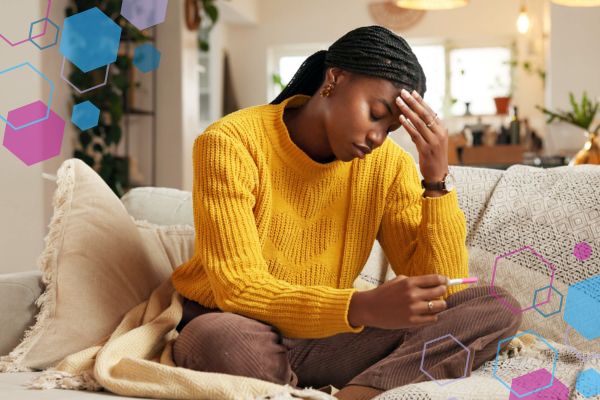 Person holding a pregnancy test and looking worried while experiencing changing symptoms in early pregnancy around 5–9 weeks.