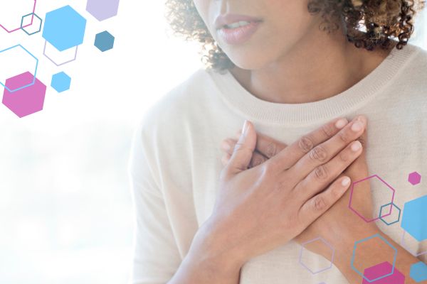 Person holding their chest, illustrating shortness of breath or feeling breathless in early pregnancy. Person holding their chest, illustrating shortness of breath or feeling breathless in early pregnancy.