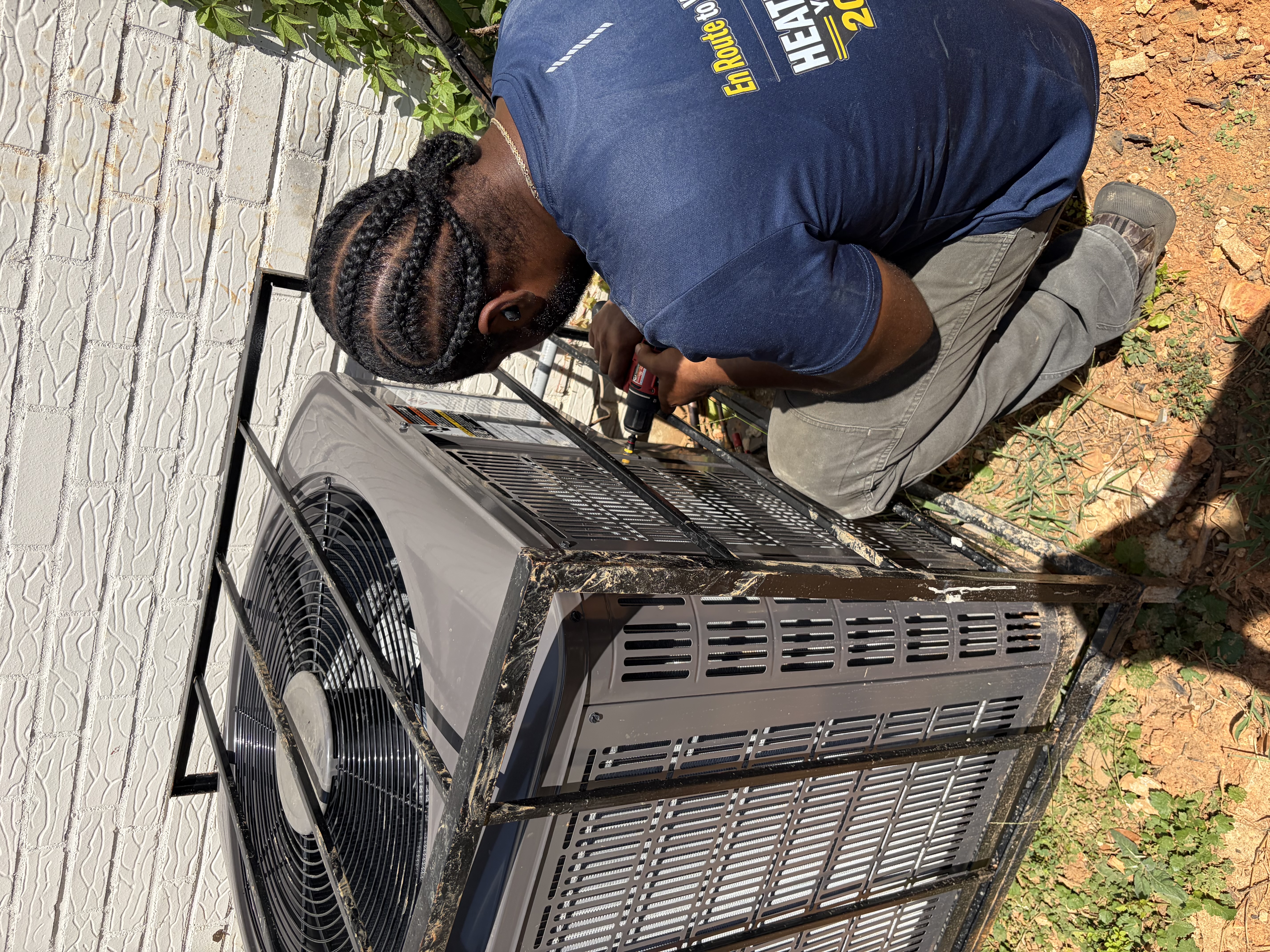 En Route Heating and Cooling technician working on an outdoor AC unit in Birmingham, Alabama