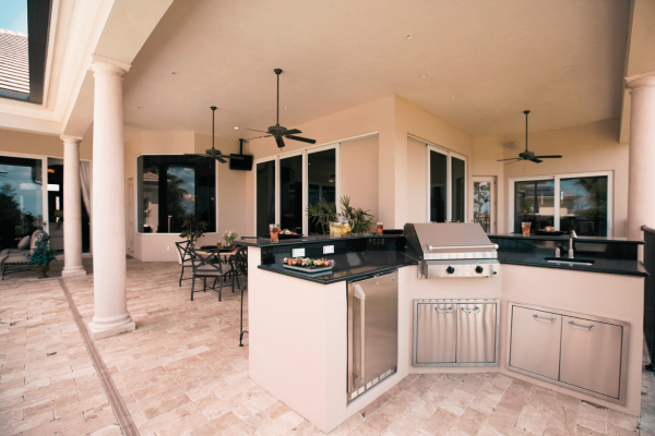 Luxury outdoor kitchen with built-in grill and stone countertops.