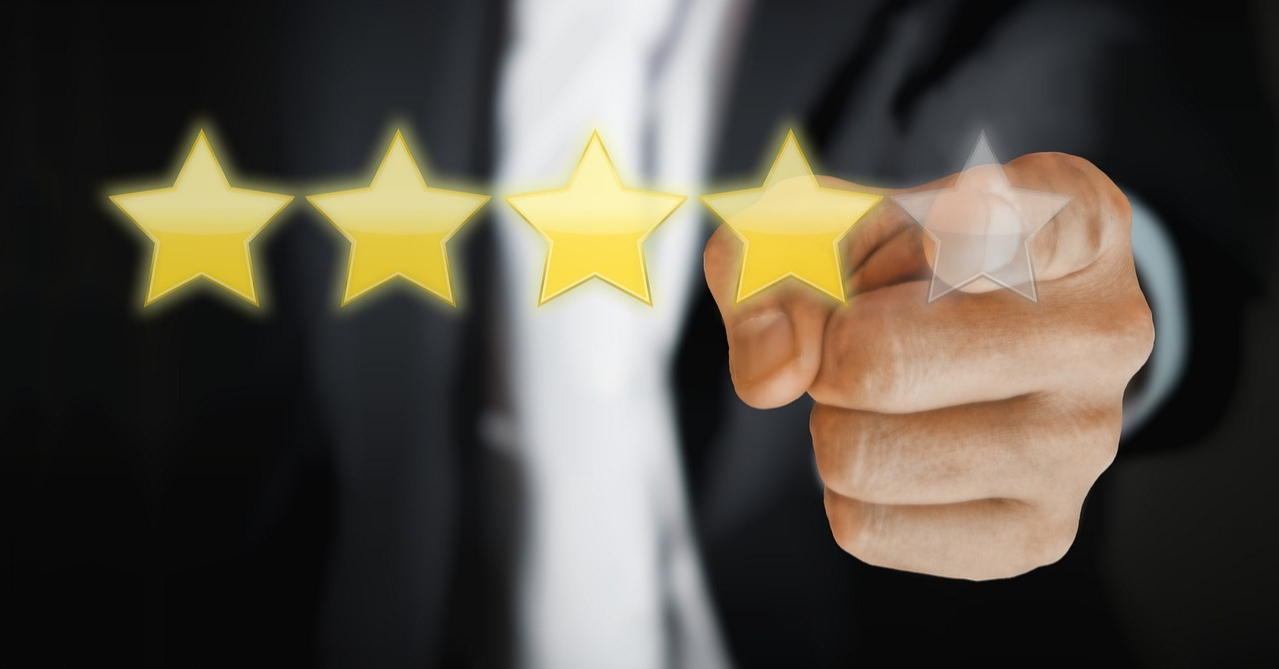 Hand pointing at gold star ratings