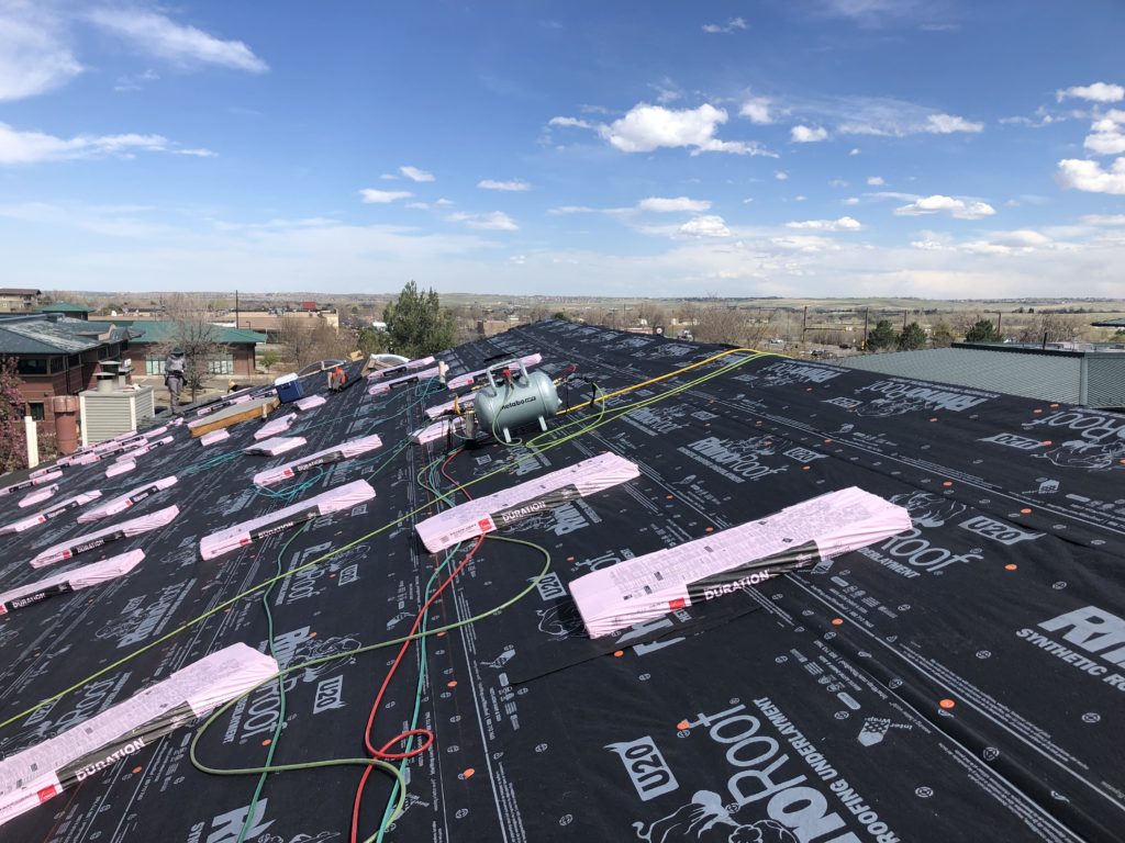 iROOF & RESTORATION crew inspecting a roof from above