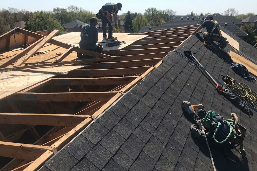 Roofing team replacing shingles and underlayment on a suburban roof in Toronto