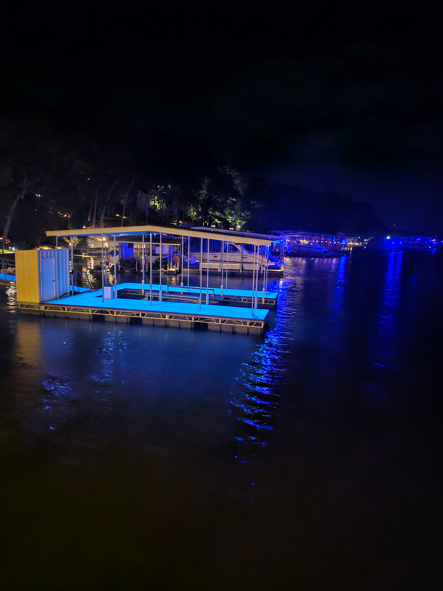 Luminex clear dock glow coating applied to a lake dock, glowing bright at night, no wires or visible hardware