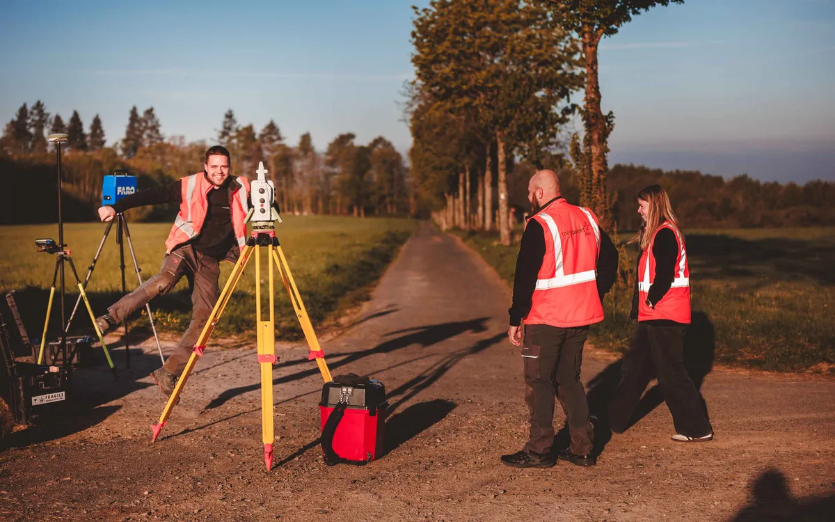 Vermesser von messpunktplus richten einen Tachymeter auf einem Feldweg ein