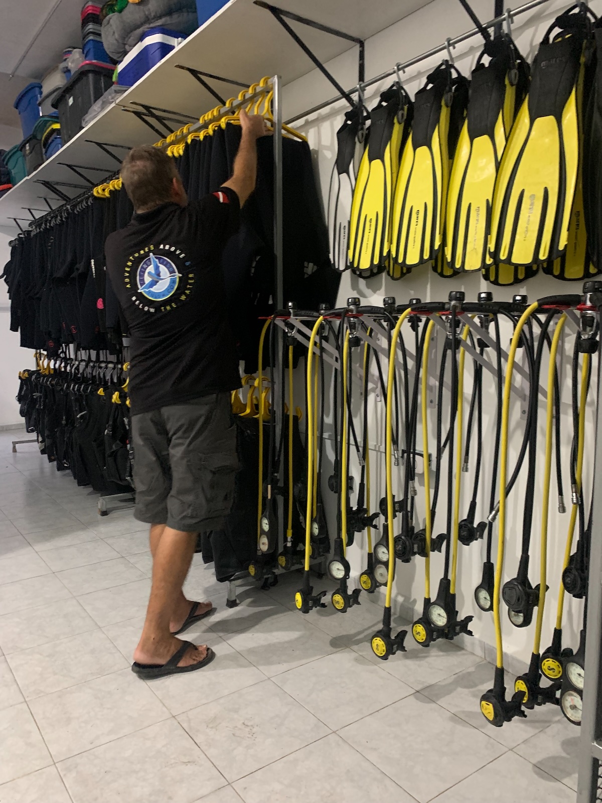 Man putting away dive equipment in a dive shop