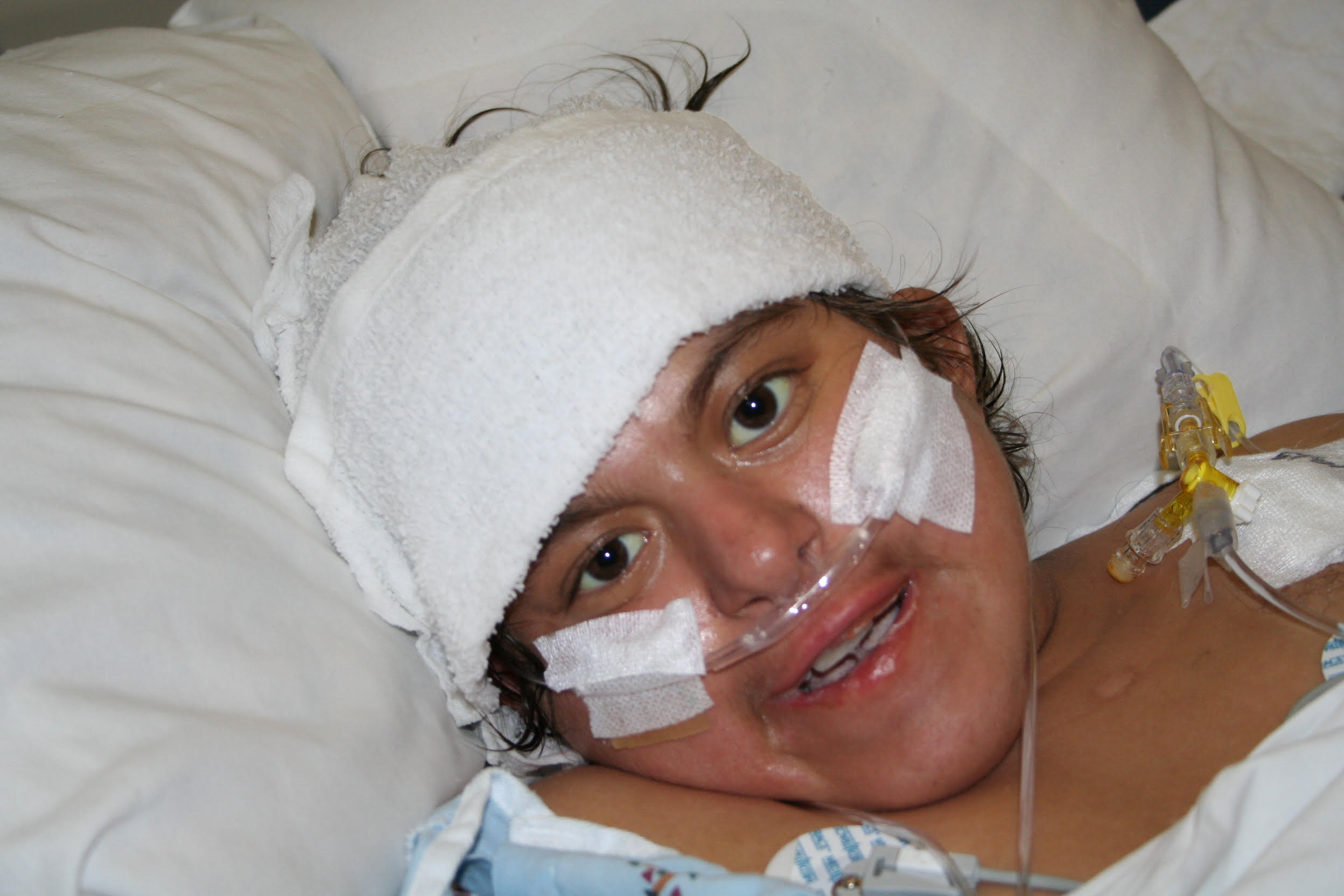 Sophia smiling from her hospital bed, bandaged but bright
