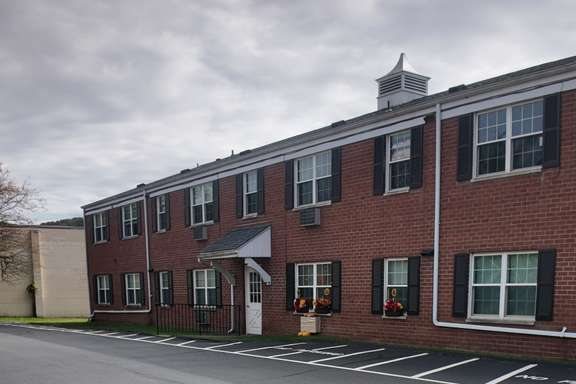 The run of brick apartment buildings at 173 E Tioga Street seen along the parking court.