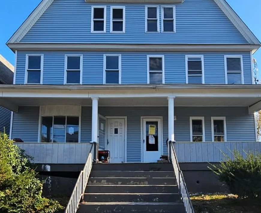 New Hancock Street, Wilkes-Barre, after the rebuild: blue siding, white trim, a white front porch with two doors and a wide flight of front steps.