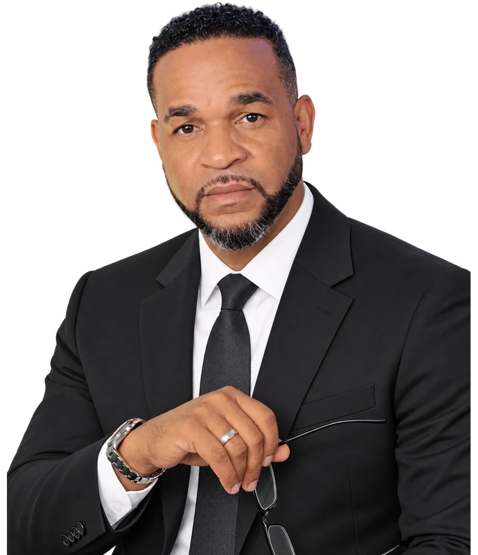 Martin Perdomo, Managing Member of Elite Strategies Consulting Group, in a dark suit and tie, holding his glasses.