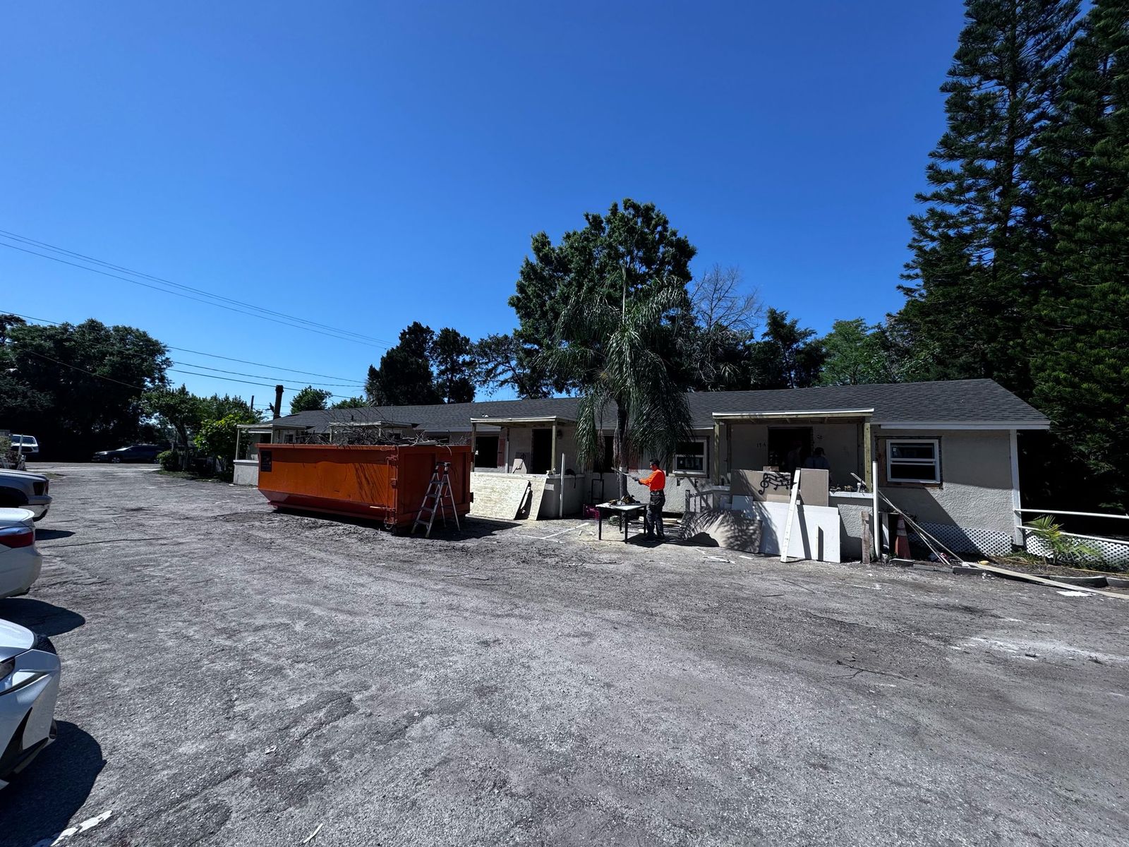 Tampa, FL multifamily building exterior during rehab, with a construction dumpster on site