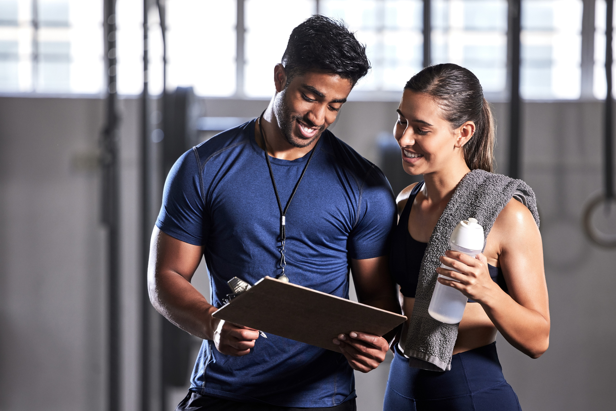 Personal trainer and client reviewing information together at a gym