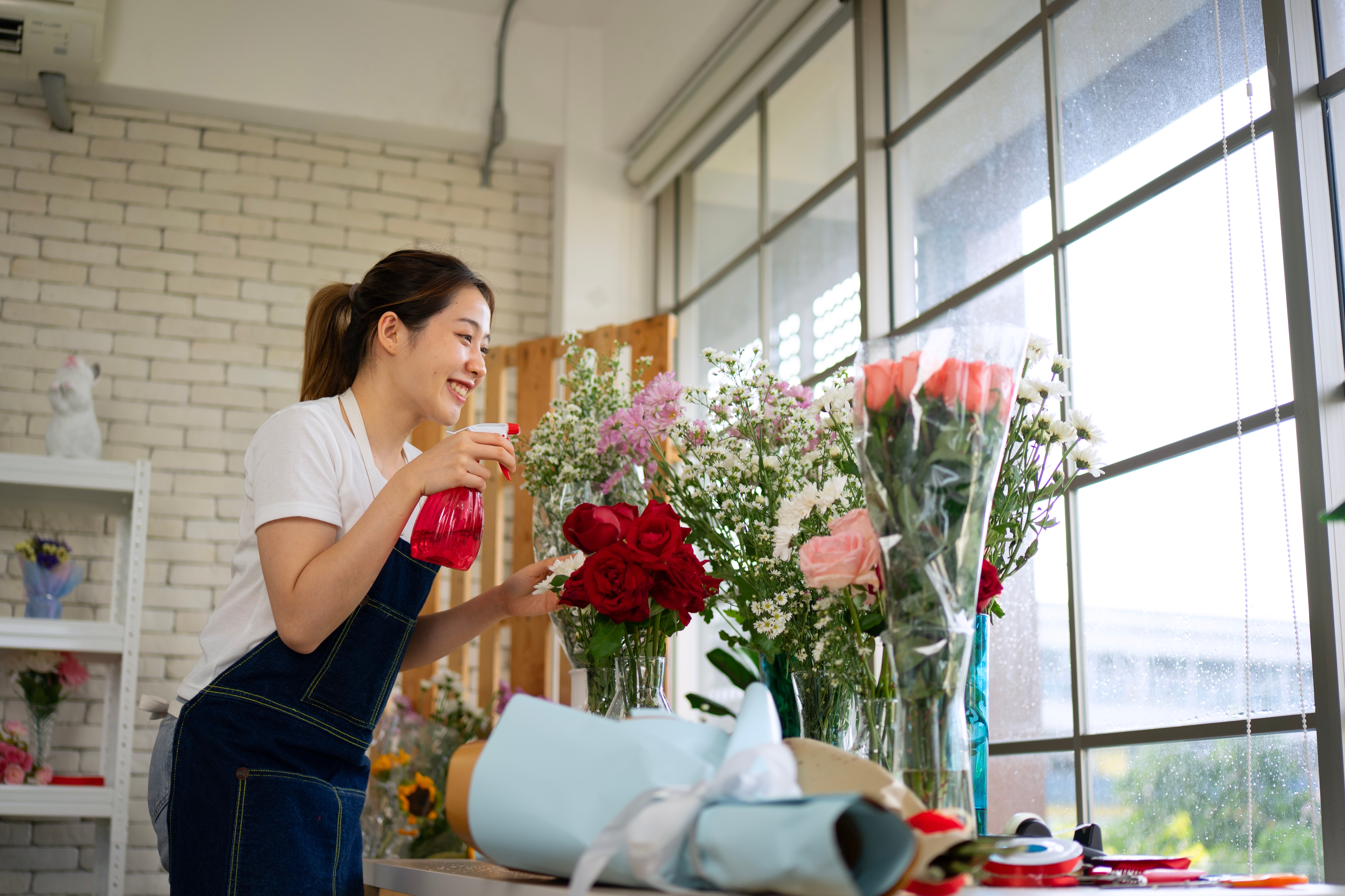 Florist working with flowers in a bright flower shop