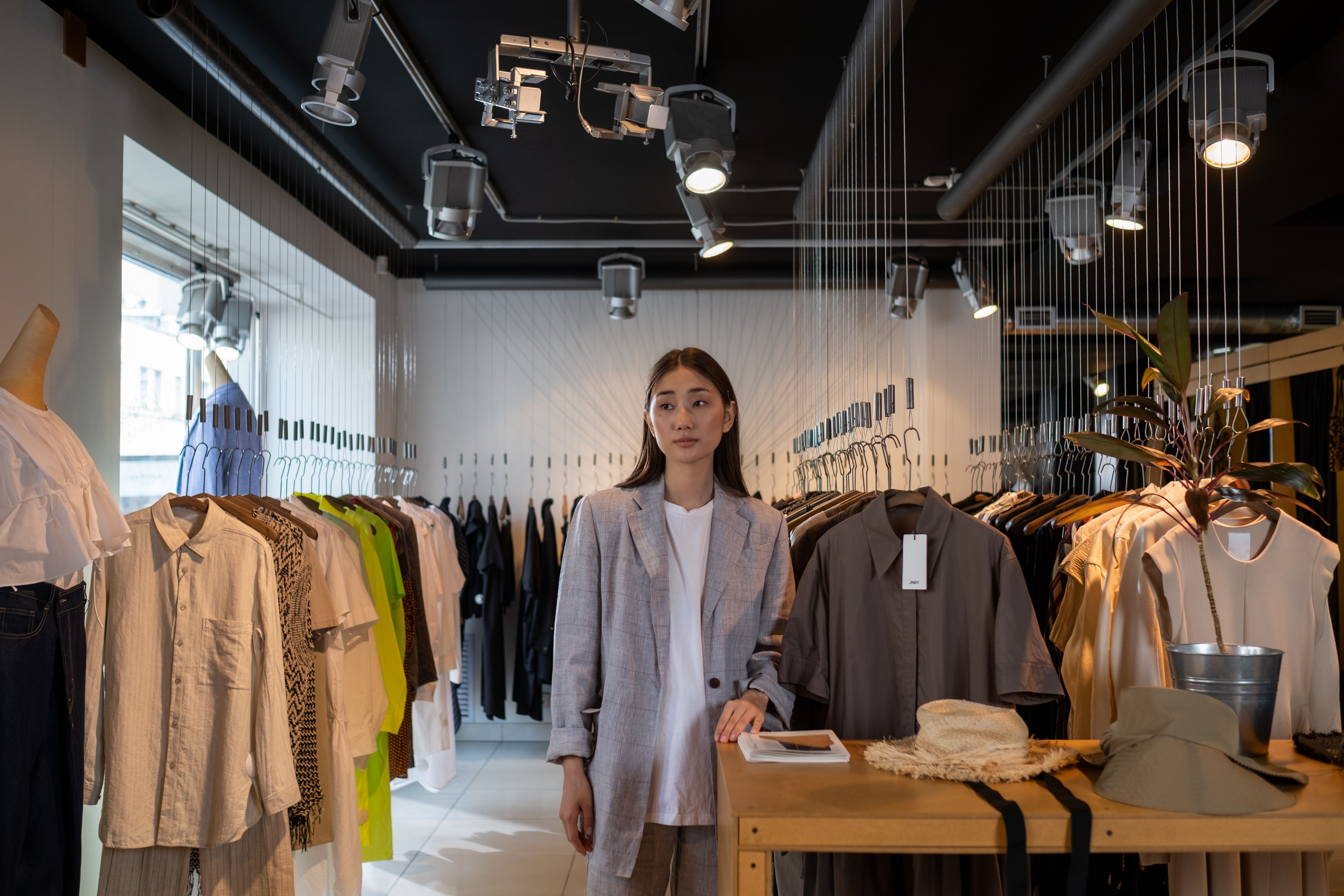 Woman standing among clothing displays in a boutique