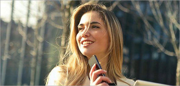 Professional woman enjoying fresh air while multitasking with her smartphone and digital tablet
