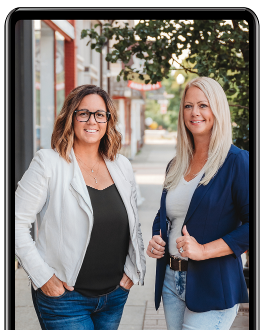 Two women standing side by side on a city sidewalk, smiling confidently while framed within a smartphone graphic.