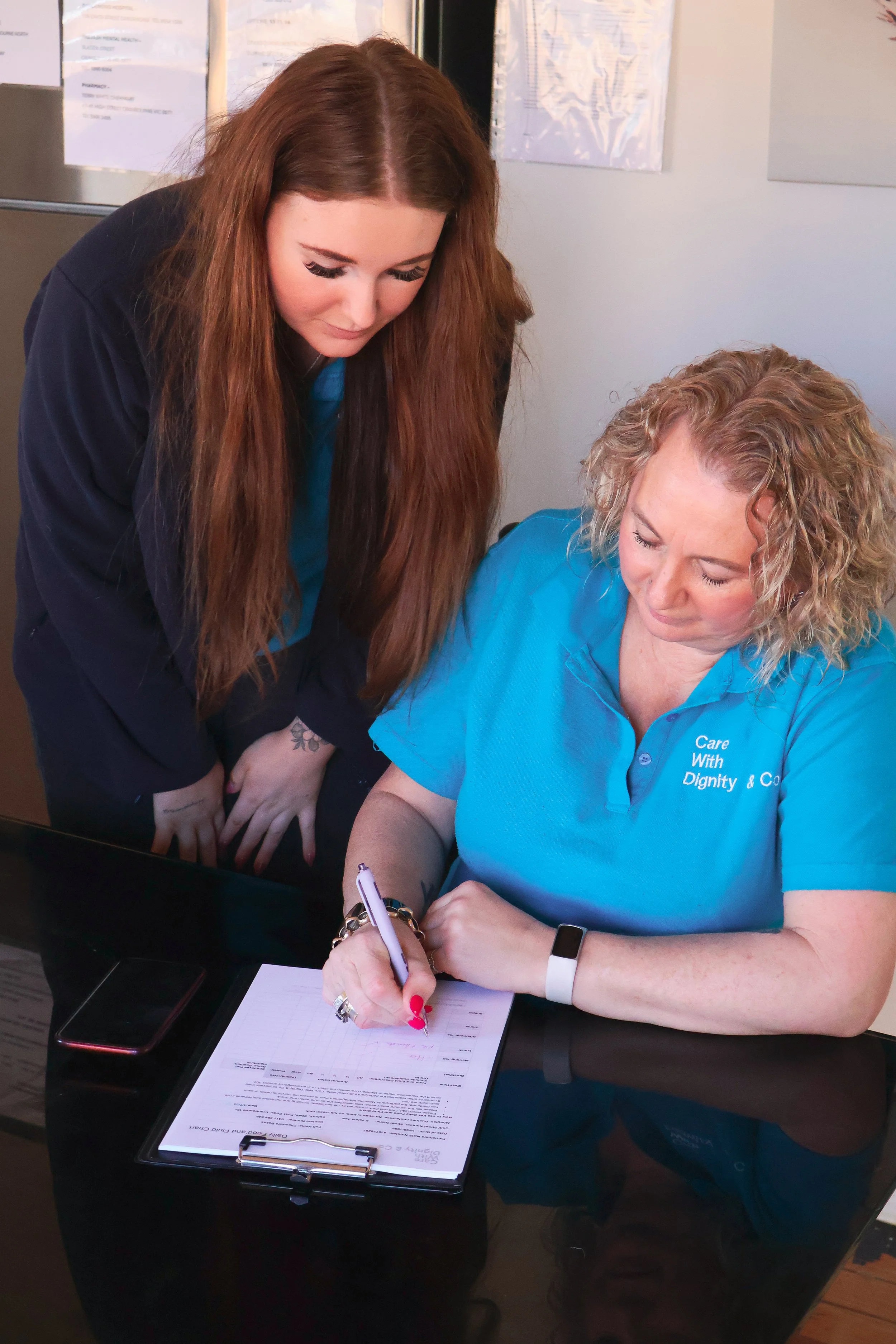 Karen and Paris filling out a referral form together