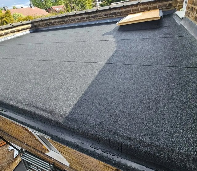 New flat-roof covering beside a stone parapet and covered roof opening