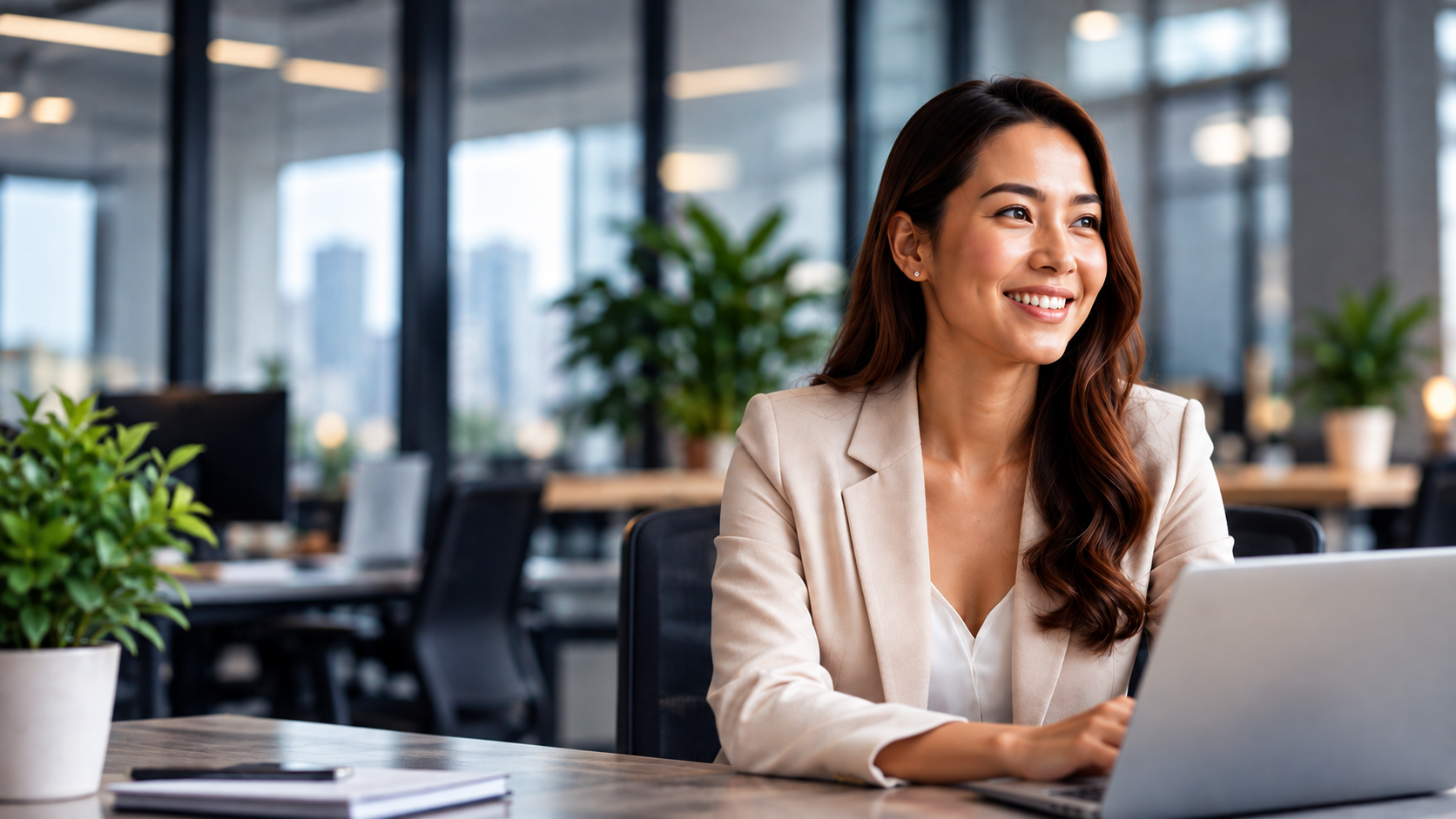 Smiling Filipino professional working at a laptop in a modern office