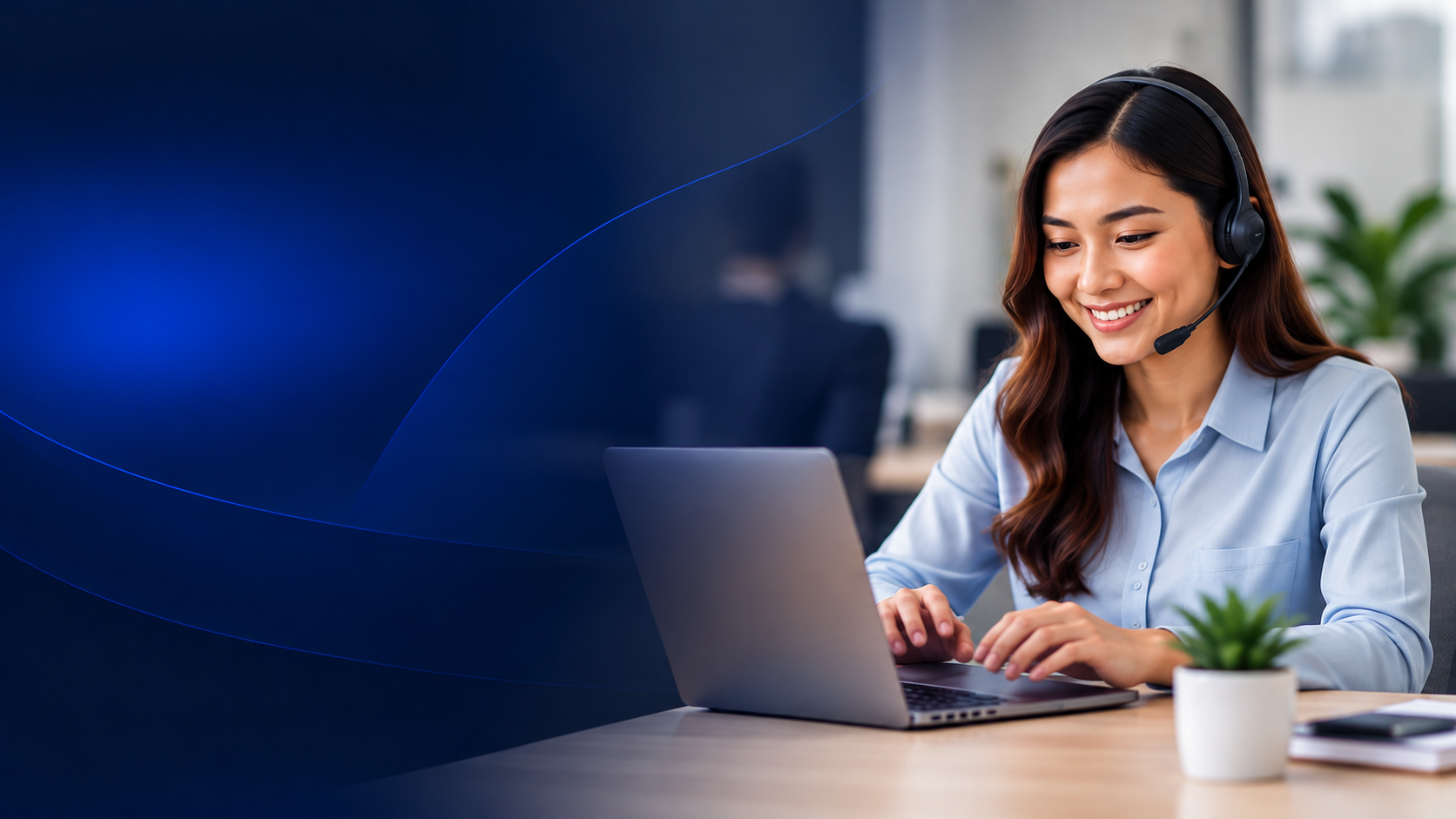 Smiling Filipino professional in a navy blazer working on a laptop