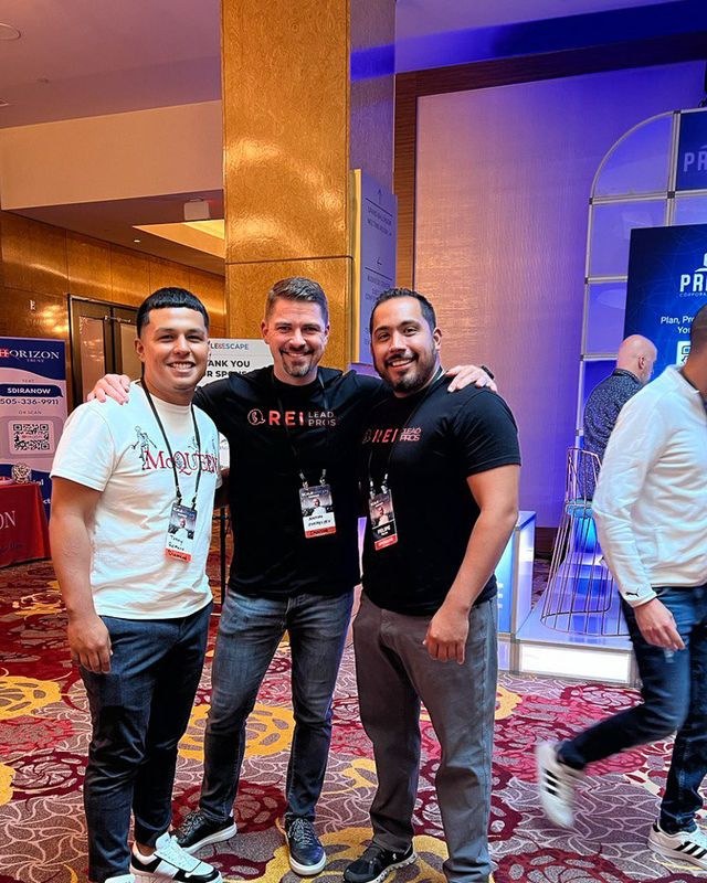 Anton with two men in REI Lead Pros shirts at an investor event