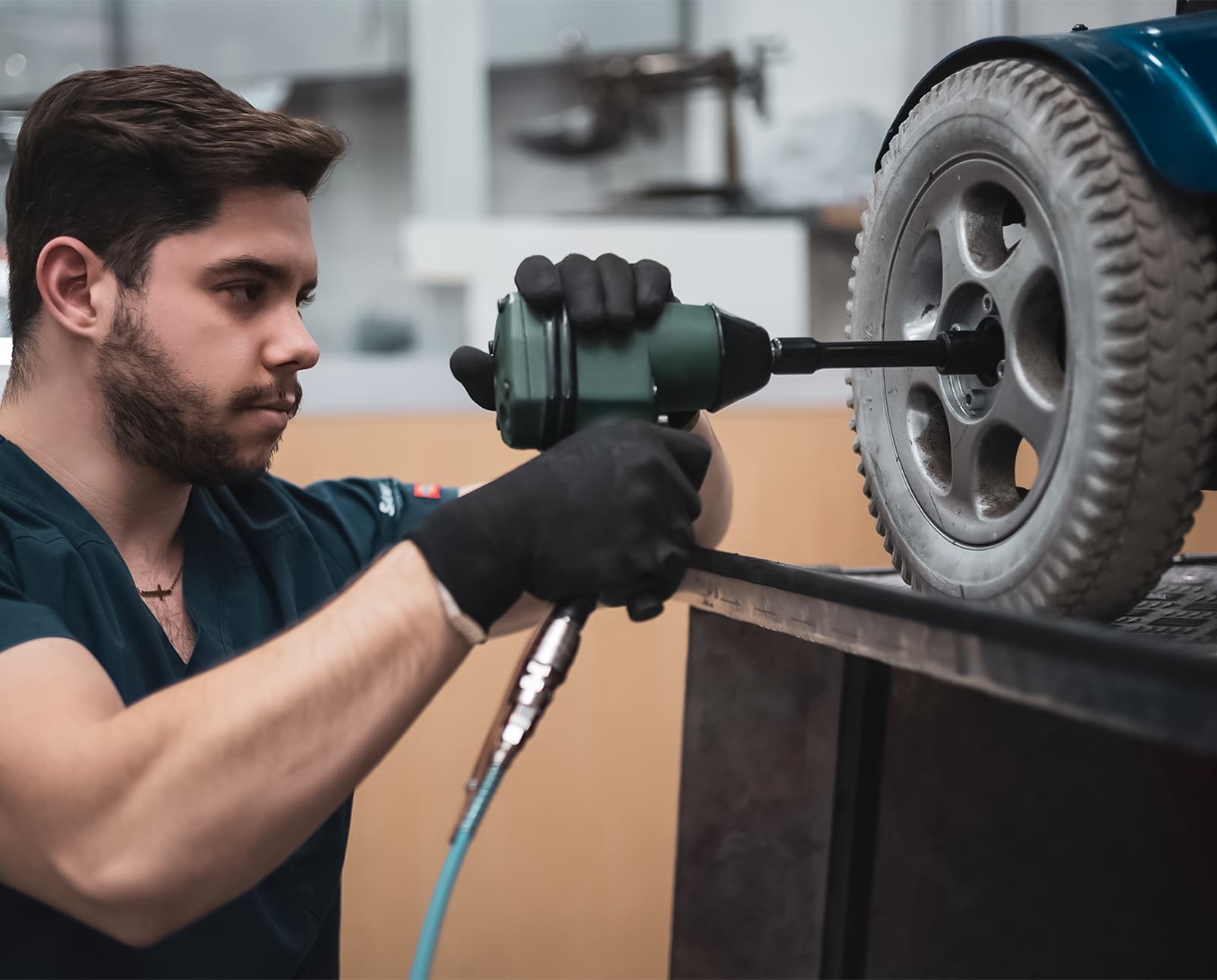 A DMR Corp technician repairing a power wheelchair wheel