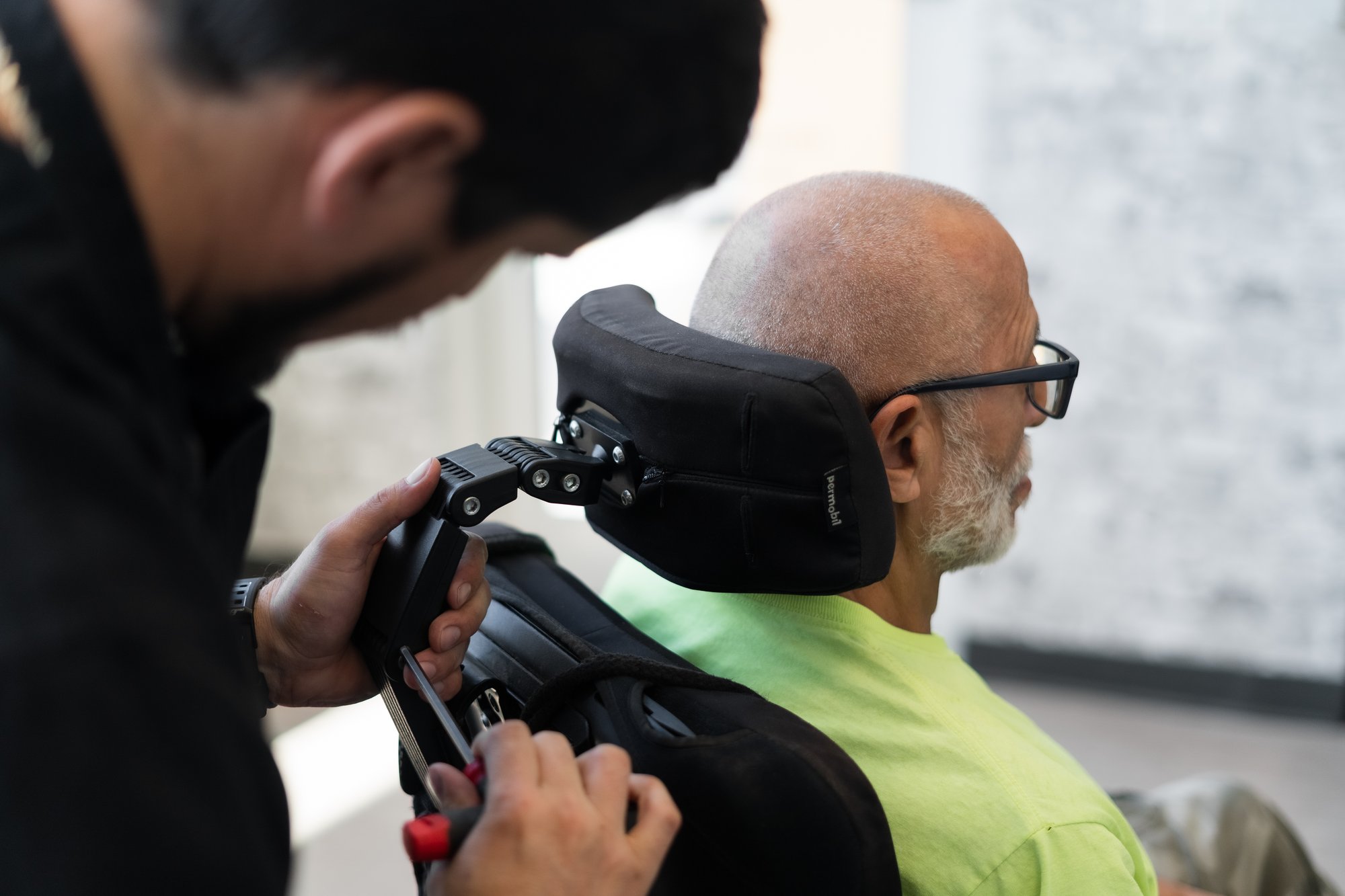 A DMR Corp specialist fitting a patient into a custom power wheelchair