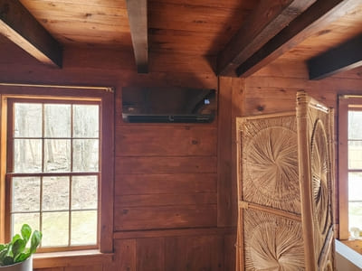 Wall-mounted air conditioning unit in a classic, wood-paneled interior, providing efficient cooling