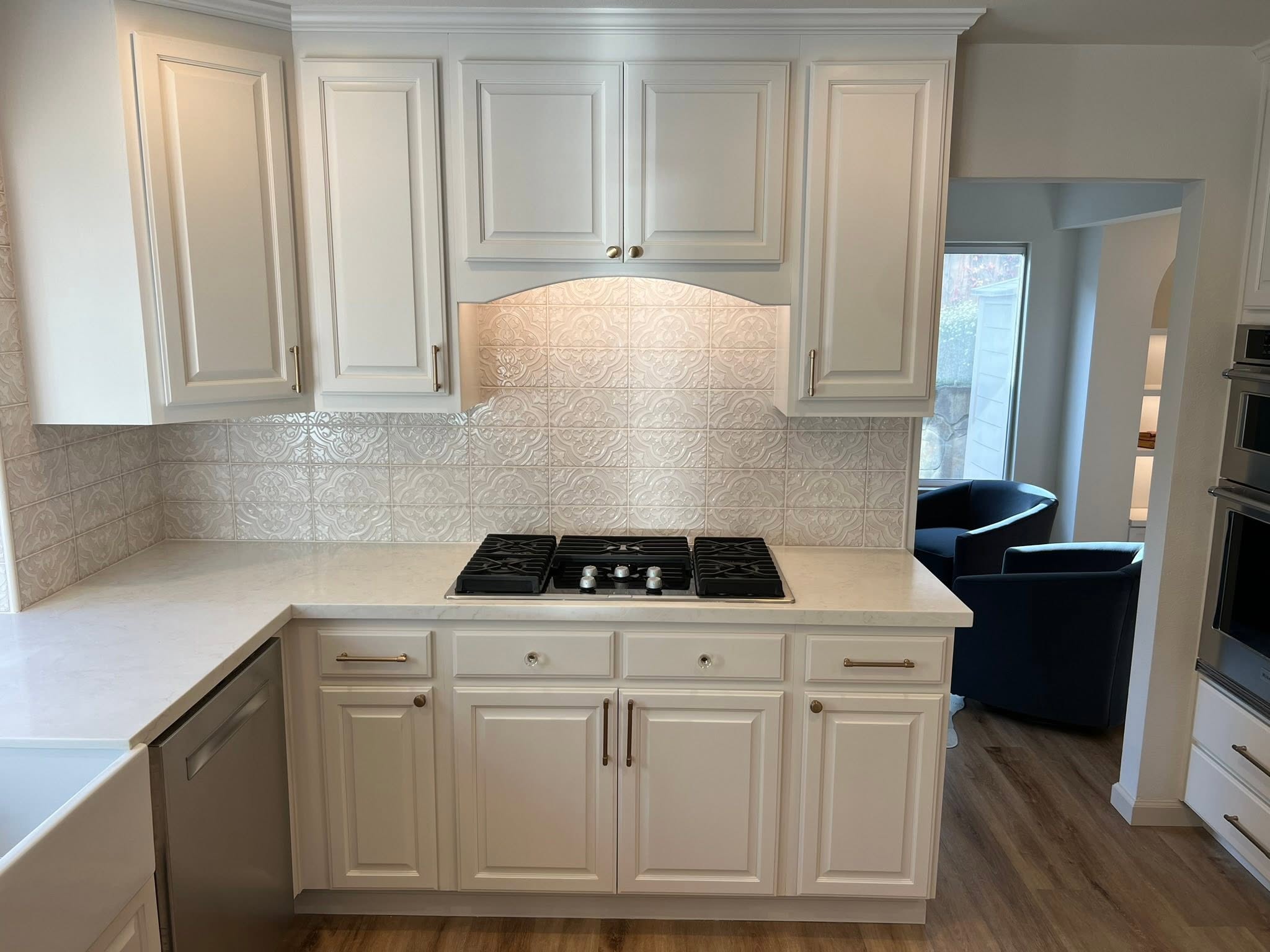 White kitchen with gas cooktop and custom cabinetry — Niche Construction