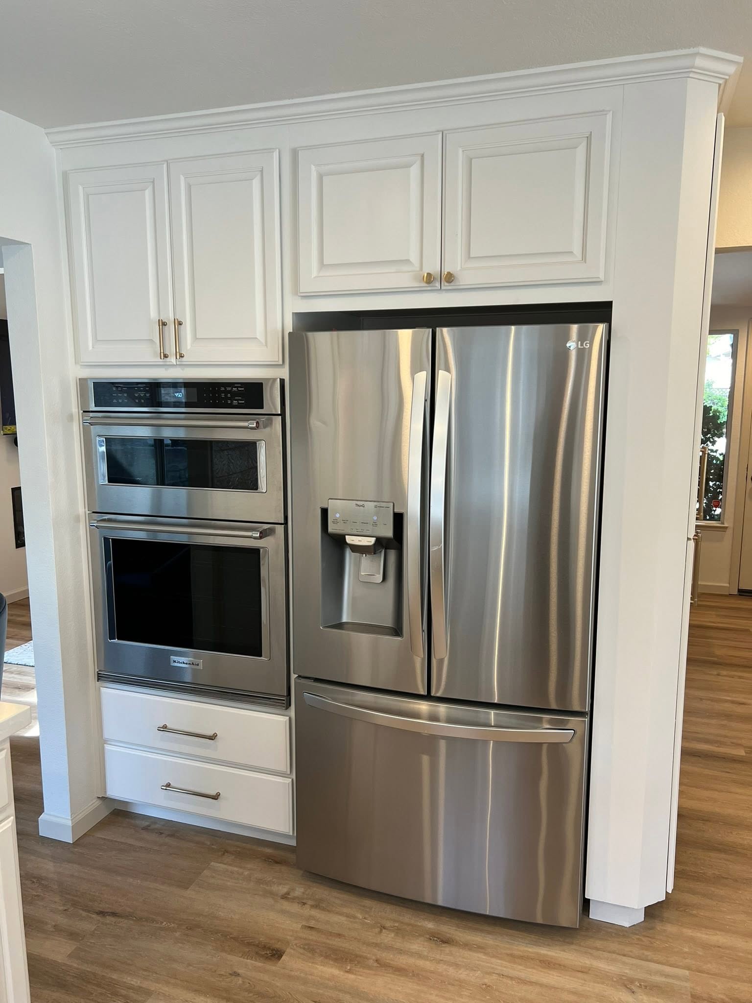 White kitchen cabinets with built-in double ovens — Niche Construction